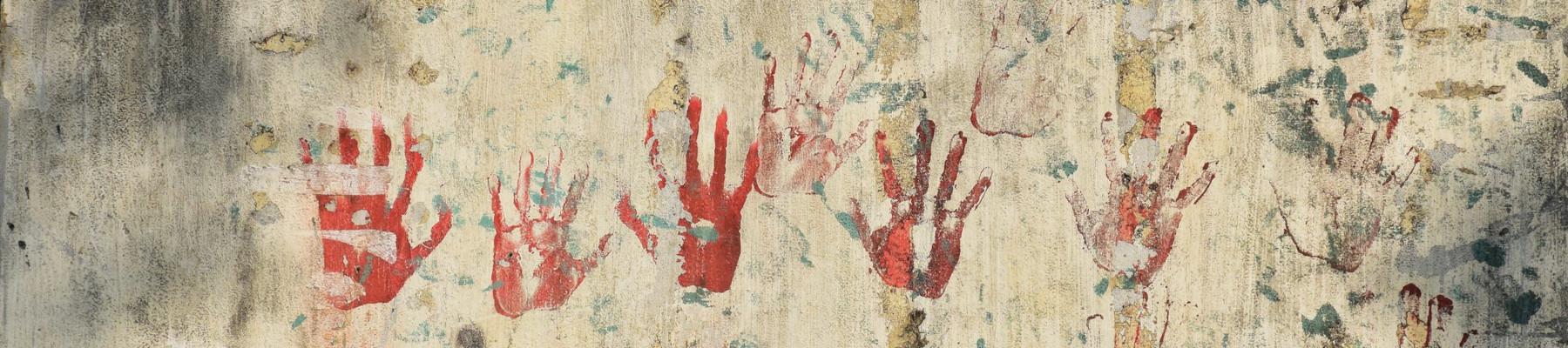 Handabdrücke in rot auf Mauer